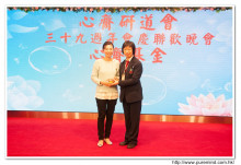 鍾孝新法師致送紀念品給去年競投聖品之熱心人士。