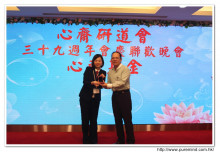 心齋基金總幹事梅婉蓉致送紀念金牌給鼎力支持心齋之熱心人士。