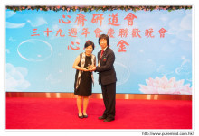 鍾孝新法師致送紀念品給去年競投聖品之熱心人士。