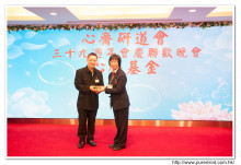 鍾孝新法師致送紀念品給去年競投聖品之熱心人士。