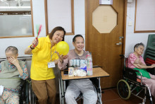 長者玩傳遞汽球遊戲時攝