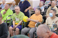 長者玩傳遞汽球遊戲時攝