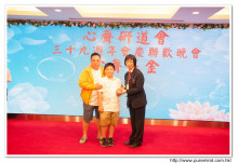 鍾孝新法師致送紀念品給去年競投聖品之熱心人士。