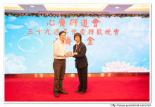 鍾孝新法師致送紀念品給去年競投聖品之熱心人士。