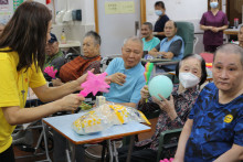 長者玩傳遞汽球遊戲時攝