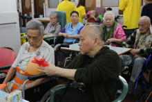 長者玩傳遞汽球遊戲時攝