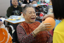 長者玩傳遞汽球遊戲時攝