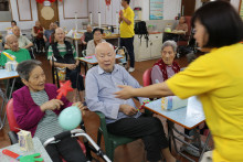 長者玩傳遞汽球遊戲時攝